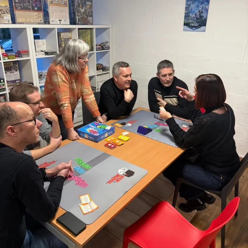 Joueurs et joueuses avec une animatrice pour expliquer les règles du jeu de société